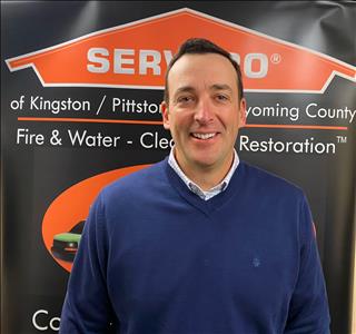 Male SERVPRO marketer in front of pop up sign 