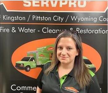 Female SERVPRO rep in front of SERVPRO sign